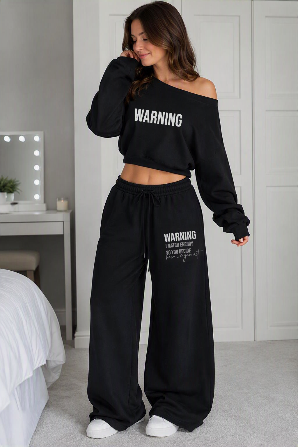 Cute, confident, and definitely not here to blend in! The WARNING™ Off-the-Shoulder Set is made for the girl who loves bold streetwear with a fun, fashion-forward vibe.

Featuring a stylish black off-the-shoulder crop top and matching wide-leg sweatpants, both finished with bold white “WARNING” lettering for an edgy statement look.
